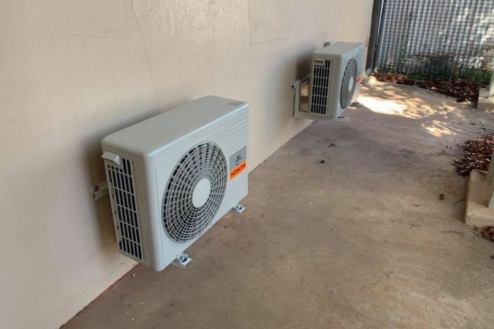 Hitachi split system outdoor units mounted on an exterior wall